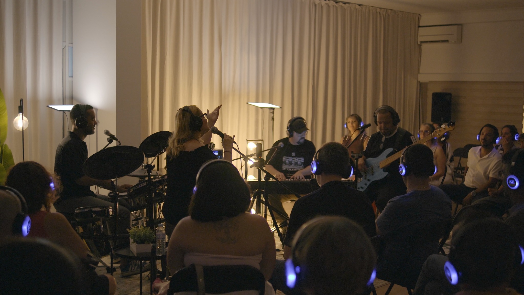 Artista convidada canta entre os músicos e o público com auscultadores