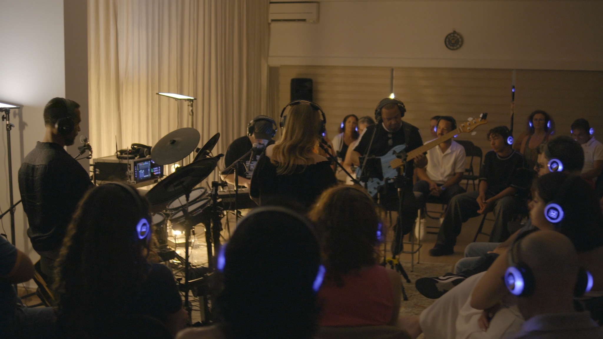 Músicos tocam rodeados pelo público durante uma sessão imersiva