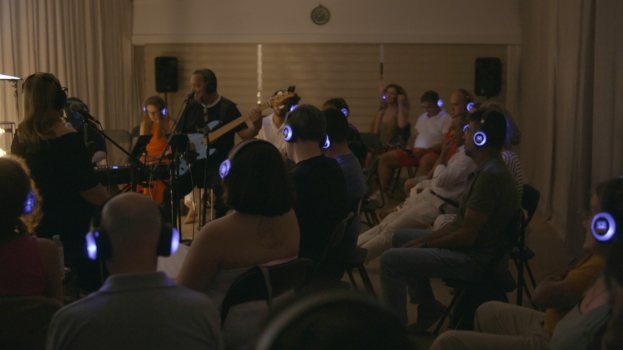 Público com auscultadores acompanha a atuação dos músicos ao vivo